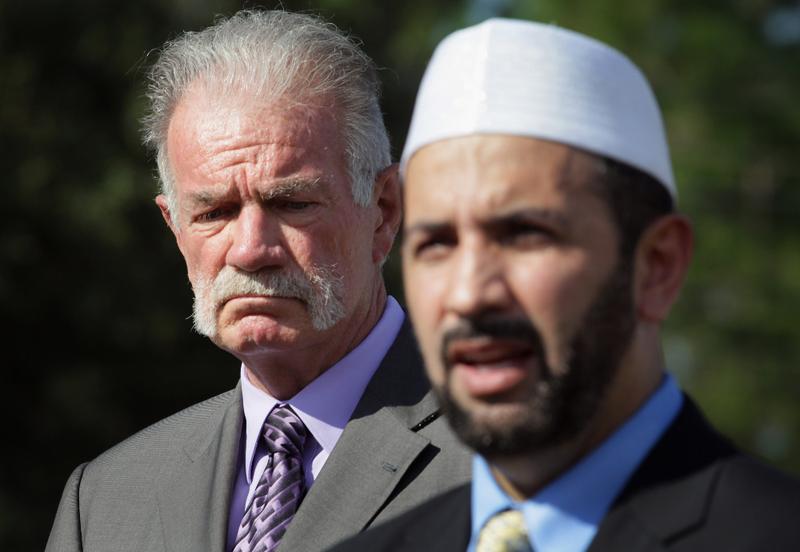 Dove World Outreach Center pastor Terry Jones (L) listens as Imam Muhammad Musri, president of the Islamic Society of Central Florida in Orlando, speaks during a press conference.